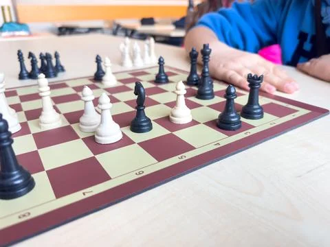 Playing chess.chess board game.Child playing chess and moving a piece in sc.. Stock Photos