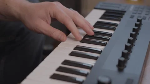 Playing chords on a small piano 4K Stock Footage 243396387