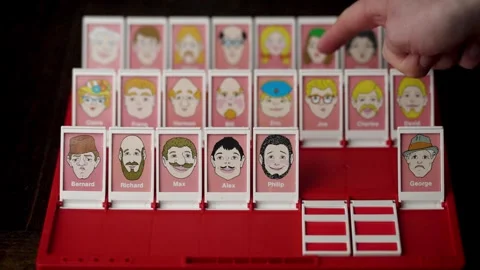 Playing classic two-player board game 'Guess Who?' Stock Footage 297770209