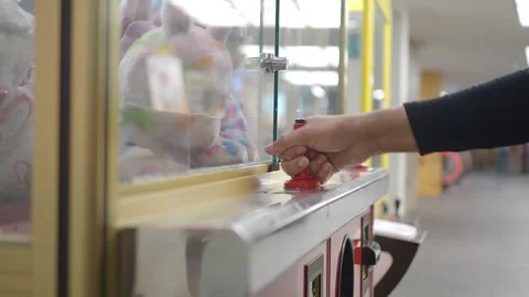Playing with a claw machine in an arcade Stock Footage 343654214