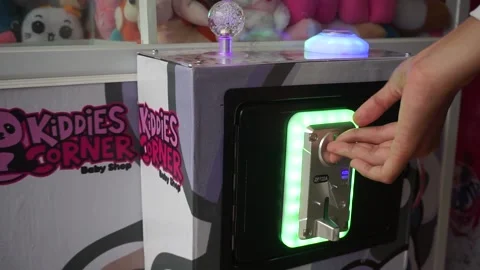 Playing with claw machine. pinch to get the doll. need coins to play 库存影片 199763098