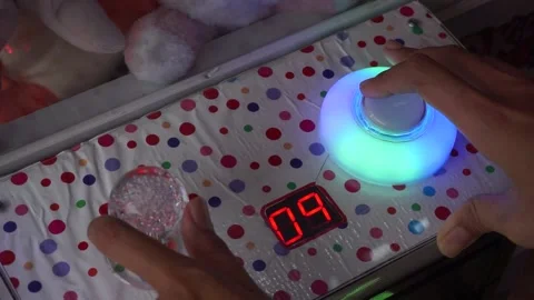 Playing with claw machine. pinch to get the doll. need coins to play 库存影片 199763119
