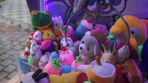 Playing with claw machine. pinch to get the doll. need coins to play 库存影片 199763136