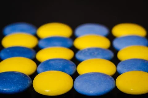 Playing with colorful candy coated chocolate buttons on a black background Stock Photos