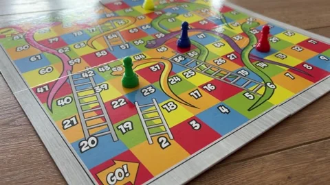 Playing a Colourful Snakes and Ladders Board Game at Home Stock Footage 341218334