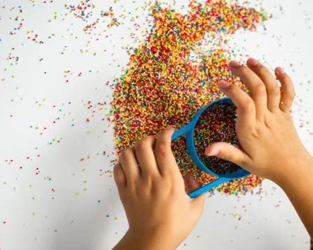 Playing with the colourful sugar sprinkles. Fun activites for children. Fine  Stock Photos