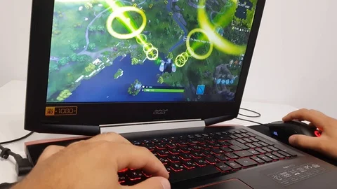 Playing a computer game called Fortnite on a laptop. Stock Footage