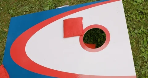 Playing Cornhole Game in Yard with Red, White and Blue Board and Bags Stock-Footage 111983413