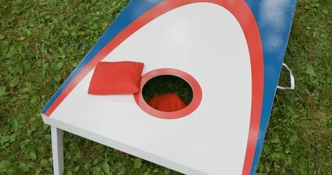 Playing Cornhole Game in Yard with Red, White and Blue Board and Bags Vídeo Stock 111983414