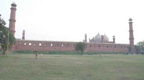 Playing cricket by the mosque Stock Footage 29821168