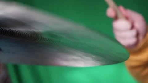 Playing A Cymbal With A Drum Stick On A Green Background Close-Up Stock Footage 292978238