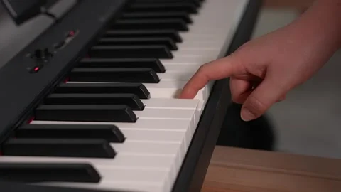 Playing the electronic piano with one finger Stock Footage 327521746