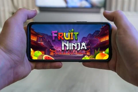 Playing Fruit ninja mobile game. Point of view gaming on smartphone Stock Photos