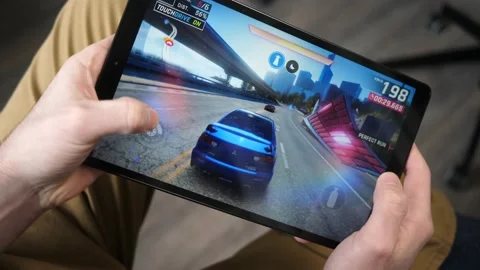 Playing a Game on a Tablet Screen Racing app Stock Footage 146999585