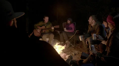 Playing guitar around a campfire Stock Footage 50192276
