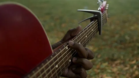 Playing guitar chords outdoors Stock Footage 236200833