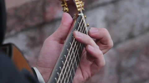 Playing guitar outside by brick wall Stock Footage 37619441