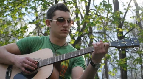 Playing guitar at the park Stock Footage 4009613