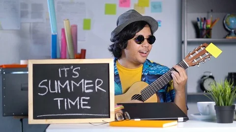 Playing Guitar While Working on Summer Vacation at Office Slow Motion Video stock 91491258