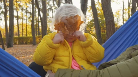 Playing hide and seek. Funny young girl hiding from somebody. Playing outside. Stock Footage 99153309