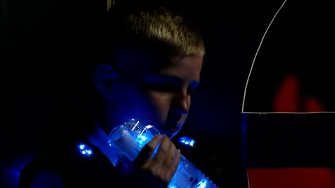 Playing laser tag boy hide from a friend with a weapon Stock Footage 77356582