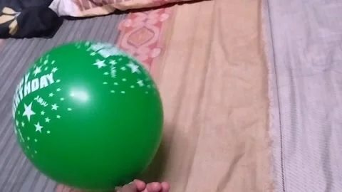 Playing a light green balloon by moving it with hands Stock Footage 325023862