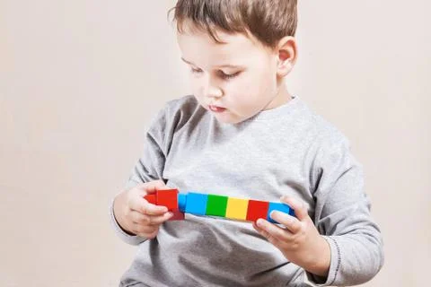 Playing little boy with colored cubes Stock Photos