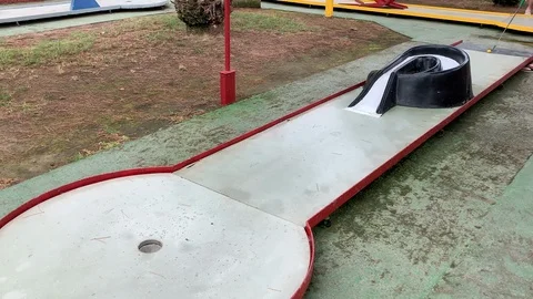 Playing mini golf outdoors in a small club Video stock 115256959
