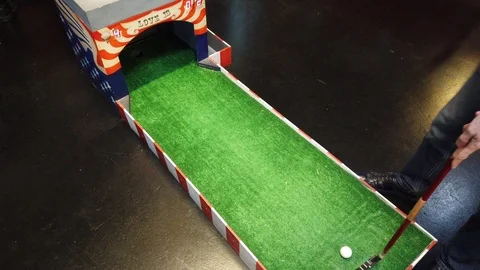 Playing mini golf. A person hitting the golf ball and hits the target Stock-Footage 122522028