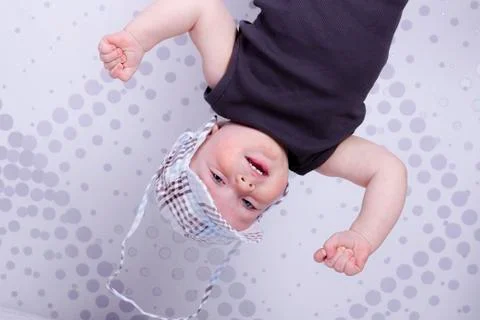 Playing like monkey funny infant boy in a cap Stock Photos