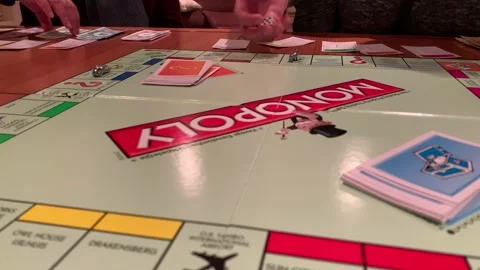 Playing monopoly board game rolling dice and Monopoly money and cards on Stock-Footage 136658935