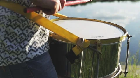 Playing a musical instrument drum or repinique  on background sky at sunset Stock Footage 64312772