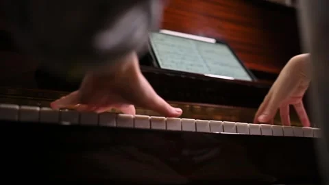 Playing a musical instrument. Reading notes from an electronic tablet. Stock Footage 262969874