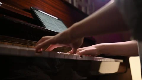 Playing a musical instrument. Reading notes from an electronic tablet. 스톡 동영상 262969956