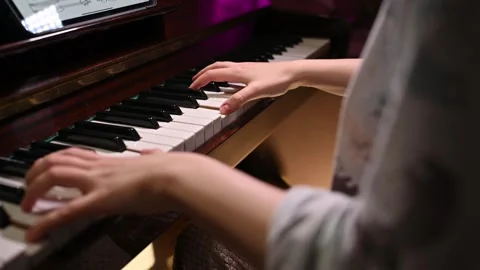 Playing a musical instrument. Reading notes from an electronic tablet. Stock Footage 262970024