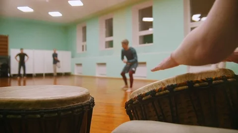 Playing a musical instruments jembe or atabaque on background male fighter Stock Footage 99041690