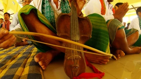 Playing on an old string instrument during the prayer of Bathau tribe in the tem Stock Footage 113285376