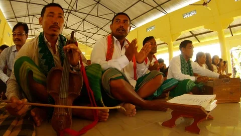 Playing on an old string instrument during the prayer of the Bodo tribe in the t Stock Footage 113286173
