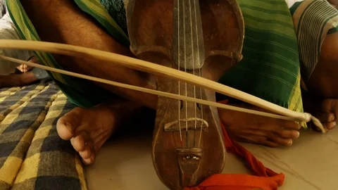 Playing on an old string instrument during the prayer of Bathau tribe in temple Stock Footage 113288386