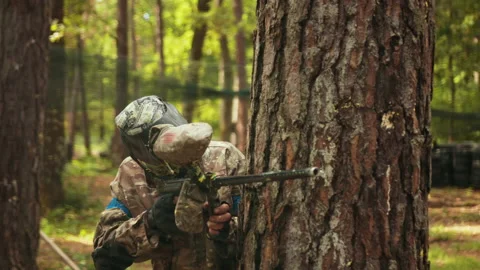 Playing paintball battles with friends while wearing camouflage protecting mask 库存影片 203498934