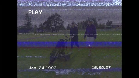 Playing partners walking golf fairway, one woman pushing cart, pausing, Stockbeeldmateriaal 333155405