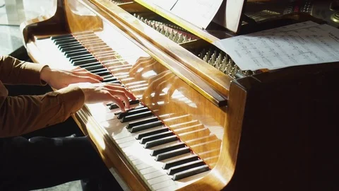 Playing piano. The young man plays a piano. The beautiful pianist plays melodies Stock Footage 72726645