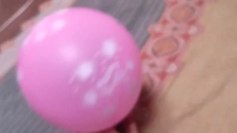 Playing with a pink balloon by moving it with hands Stock Footage 325023860