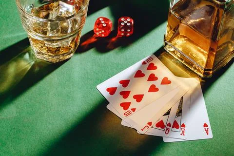 Playing poker with whiskey and cigars on table Stock Photos