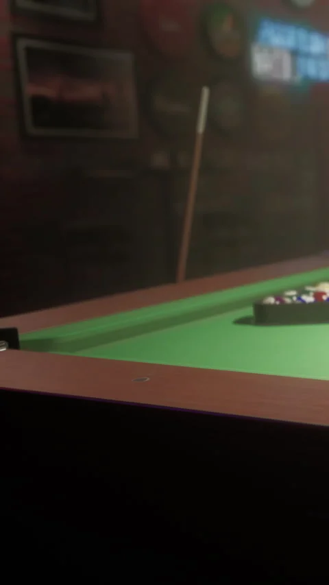 Playing pool in a dim bar with friends during a weekend night Stock Footage 342347776