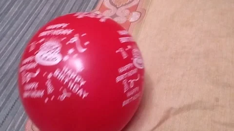 Playing with a red balloon by moving it with your hand Stock Footage 325023861