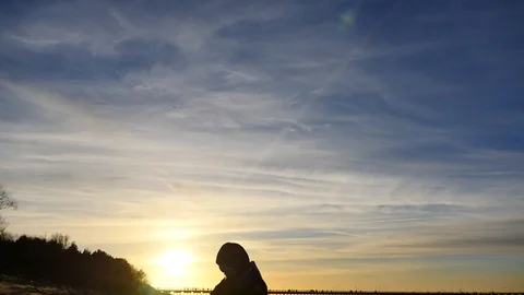 Playing on sand 2 years old boy in winter clothes silhouette Stock Footage 100290293