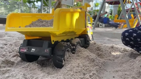 Playing with sand and sand trucks on the playground Stock Footage 272723688