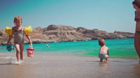 Playing with Sand and Waves on The Beach on a Summer Day Stock Footage 60380306