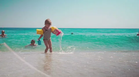 Playing with Sand and Waves on The Beach on a Summer Day Stock Footage 60380490